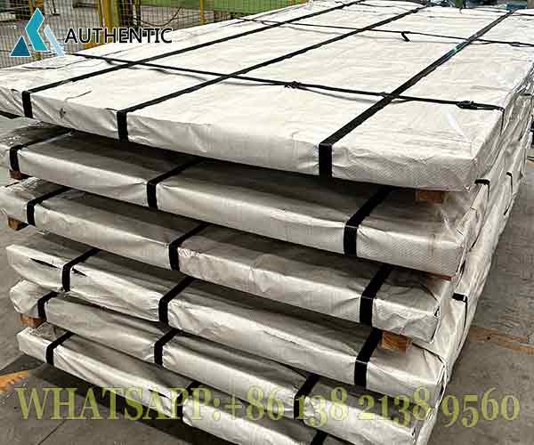 Proses bundling kokoh pada Atap Galvanis dengan pengikat plat besi untuk menjamin keamanan fisik produk dari goresan saat logistik jalur laut.