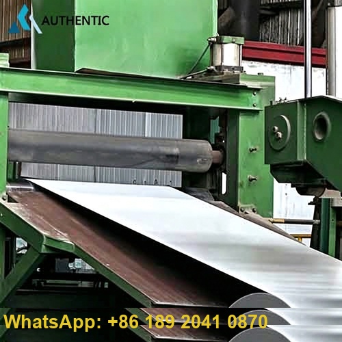 Experienced warehouse specialist applying heavy-duty waterproof protection during the manual packing process of printed PPGI steel coil at Authentic Steel factory.